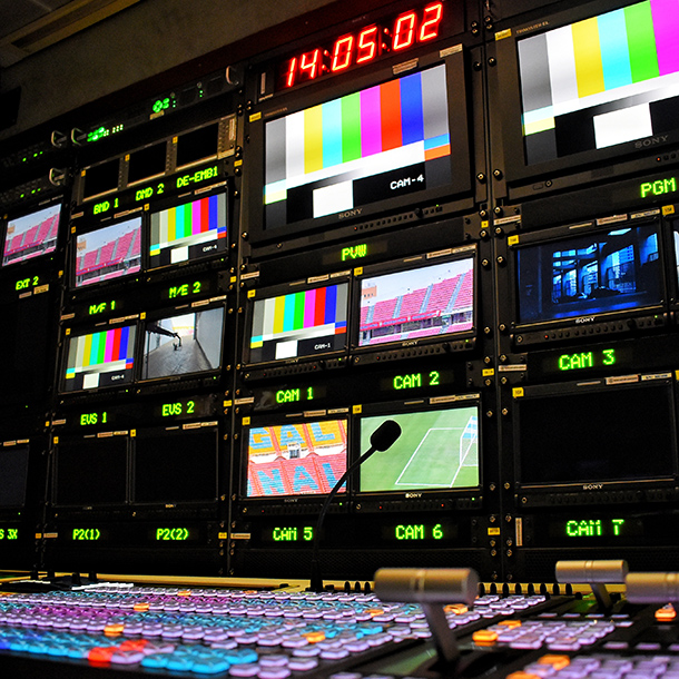 A news broadcast control centre with numerous screens and controls.
